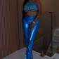 Model wearing Ocean Envy blue metallic two-piece set with underboob halter crop top and shiny high-waist pants