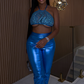 Model wearing Ocean Envy blue metallic two-piece set with underboob halter crop top and shiny high-waist pants
