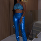 Model wearing Ocean Envy blue metallic two-piece set with underboob halter crop top and shiny high-waist pants
