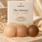 Three round silicone lip sealers in light beige, medium tan, and dark brown are lined up in front of their white and gold packaging box, which reads 'SLAEBYRTEN The Ultimate Lip Seal'. The scene is styled with a textured stone slab and draped beige fabric.